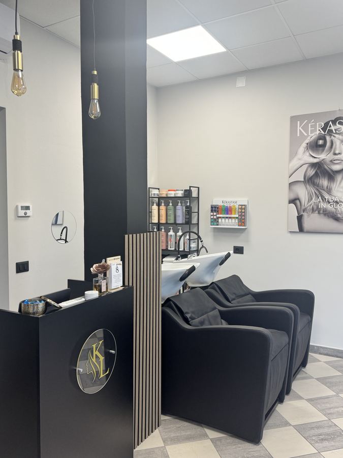 Banco nero con il logo dorato Kasa Luci e le lampadine sospese